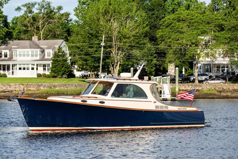 Gracious Yacht Photos Pics Hinckley Picnic Boat Mark III 2011 cruising on a serene river near elegant waterfront homes.