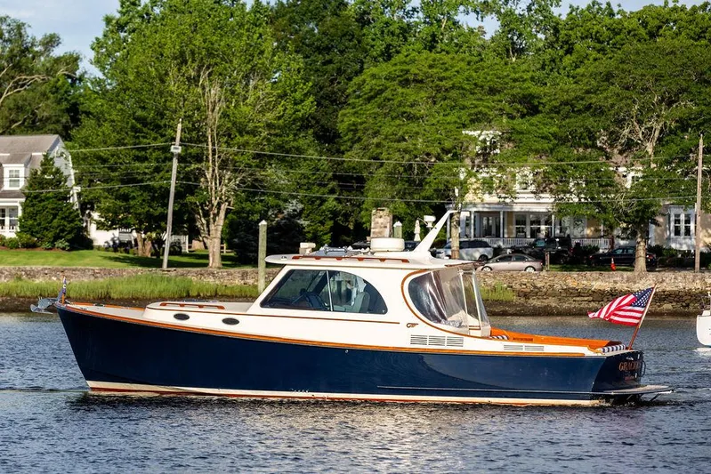 Gracious Yacht Photos Pics 2011 Hinckley Picnic Boat Mark III cruising on a scenic river with lush greenery.