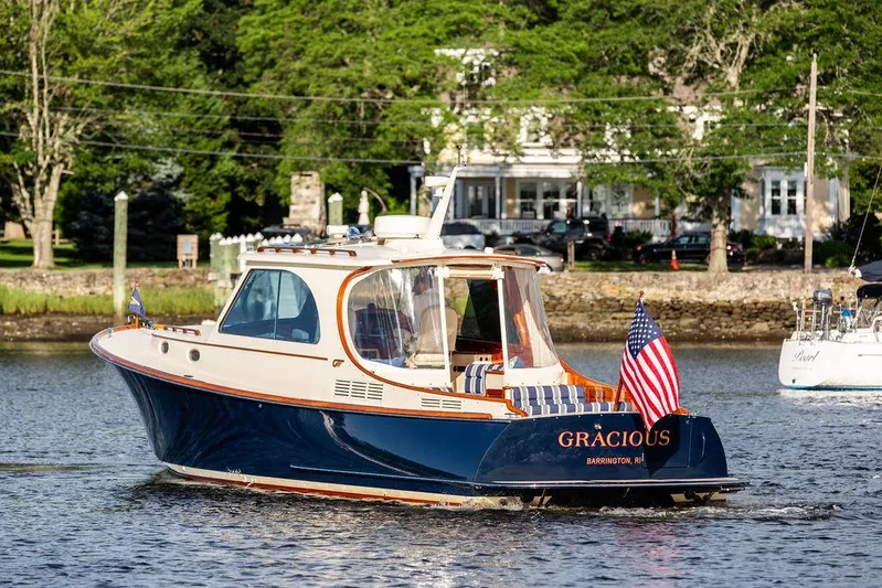 Gracious Yacht Photos Pics 2011 Hinckley Picnic Boat Mark III cruising on a scenic river with American flag.