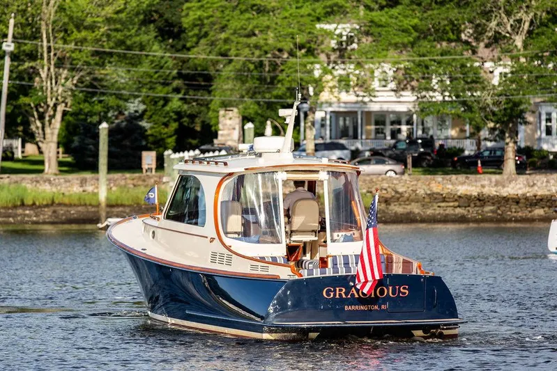 Gracious Yacht Photos Pics Hinckley Picnic Boat Mark III, 2011, cruising on a serene river with lush greenery.
