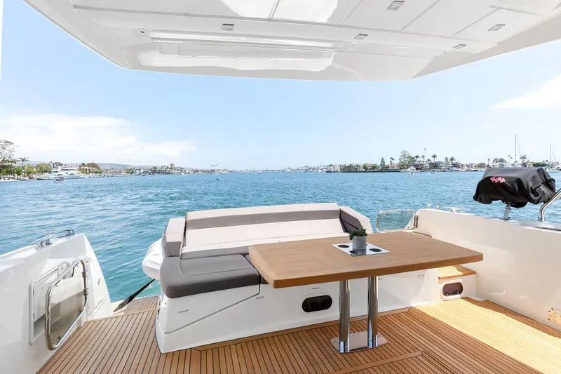 Florita Yacht Photos Pics Prestige 550 yacht deck with seating and table, overlooking serene blue waters, 2016 model.