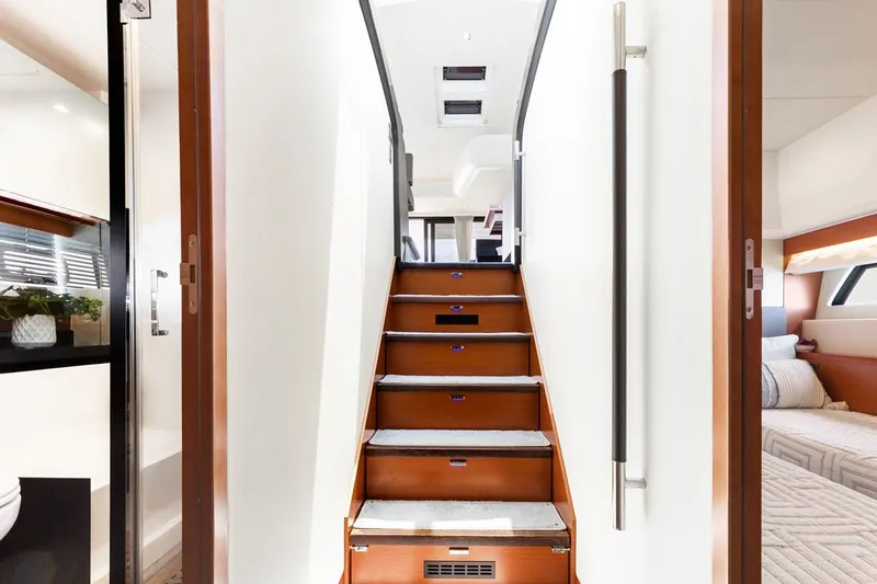 Florita Yacht Photos Pics Interior staircase of 2016 Prestige 550 yacht, featuring modern design and wood accents.