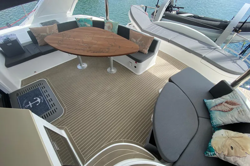 Weihaii Yacht Photos Pics Luxurious 2023 Xquisite Yachts X5 PLUS deck with elegant seating and wooden table.