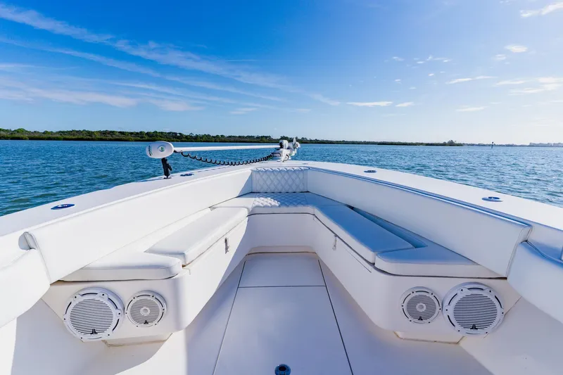  Yacht Photos Pics 2025 Contender 32 ST boat interior with white seating, on calm blue water.