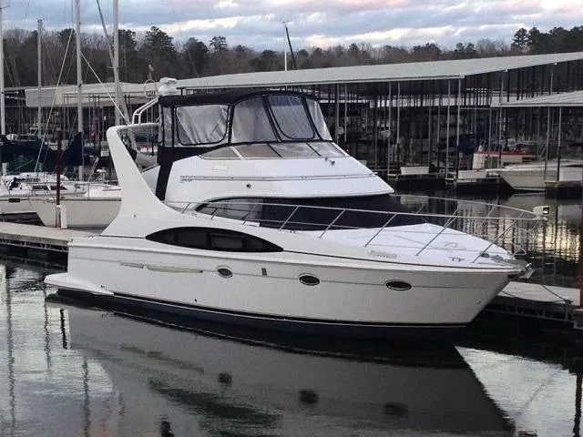 Why Knot Yacht Photos Pics 2003 Carver 410 Sport Sedan yacht docked at marina, surrounded by calm water.