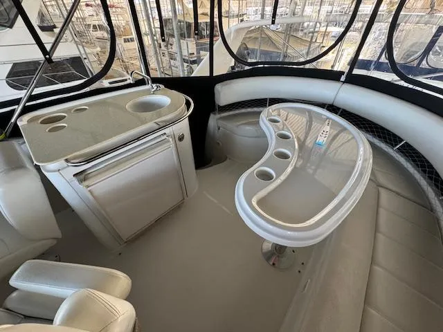 Why Knot Yacht Photos Pics 2003 Carver 410 Sport Sedan interior with seating, table, and kitchenette.