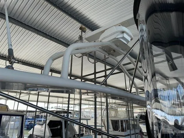 Why Knot Yacht Photos Pics 2003 Carver 410 Sport Sedan radar arch under a metal roof in a marina.