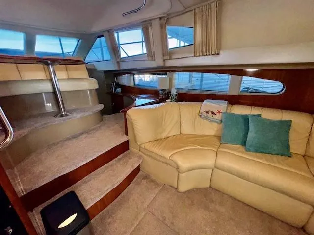 Why Knot Yacht Photos Pics Interior of 2003 Carver 410 Sport Sedan with beige seating and carpeted steps.