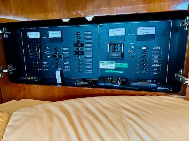 Why Knot Yacht Photos Pics Electrical control panel inside 2003 Carver 410 Sport Sedan yacht, featuring various switches and meters.