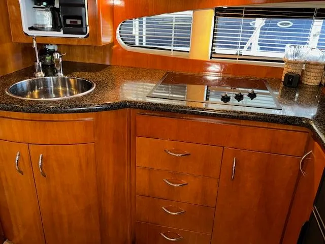 Why Knot Yacht Photos Pics 2003 Carver 410 Sport Sedan kitchen with wood cabinetry, sink, and stovetop.