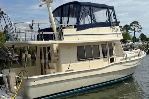 Figur'in It Out Yacht Photos Pics 2006 Mainship 400 Trawler docked, featuring a spacious upper deck and classic design.