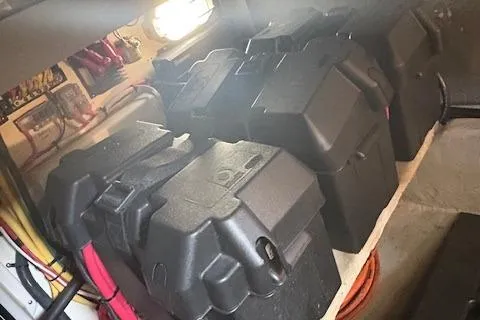 Figur'in It Out Yacht Photos Pics Battery compartment of a 2006 Mainship 400 Trawler, featuring multiple secured batteries.