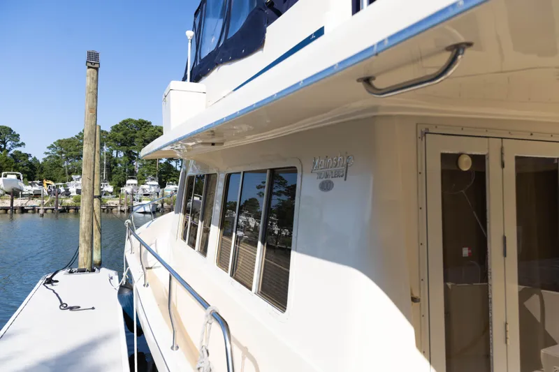 Figur'in It Out Yacht Photos Pics 2006 Mainship 400 Trawler docked at marina, sunny day, clear blue sky.