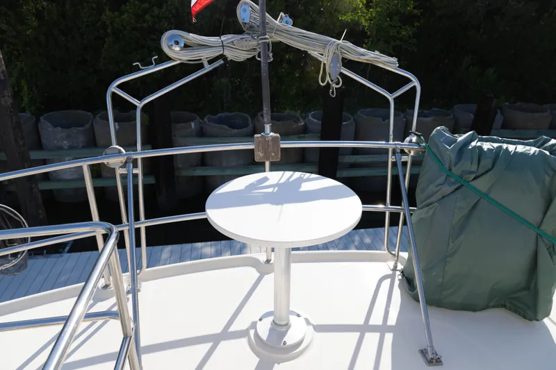 Figur'in It Out Yacht Photos Pics 2006 Mainship 400 Trawler deck with railing, table, and covered equipment.