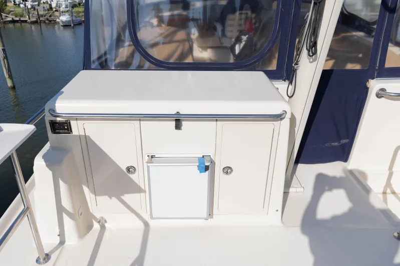 Figur'in It Out Yacht Photos Pics 2006 Mainship 400 Trawler deck with storage compartments and railing, dockside view.