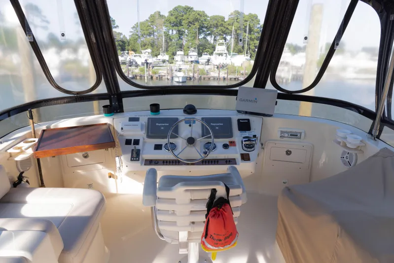 Figur'in It Out Yacht Photos Pics Helm of 2006 Mainship 400 Trawler with navigation equipment and marina view.