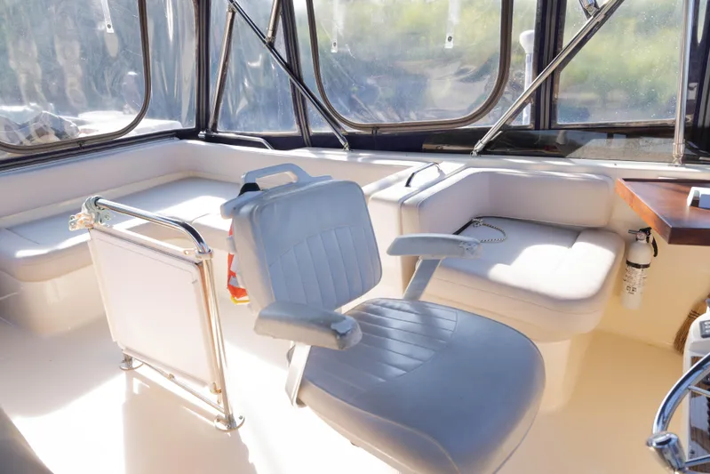 Figur'in It Out Yacht Photos Pics 2006 Mainship 400 Trawler interior with seating and windows, featuring a captain's chair and safety equipment.