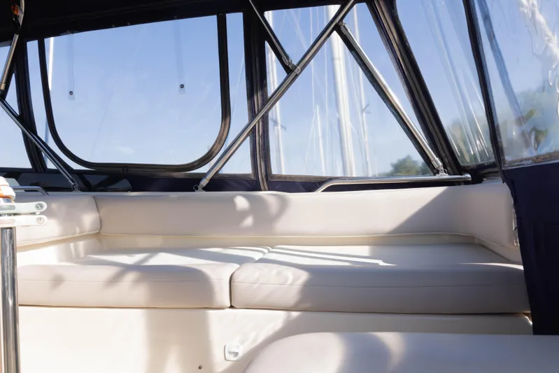 Figur'in It Out Yacht Photos Pics Interior seating area of a 2006 Mainship 400 Trawler with cushioned seats and windows.