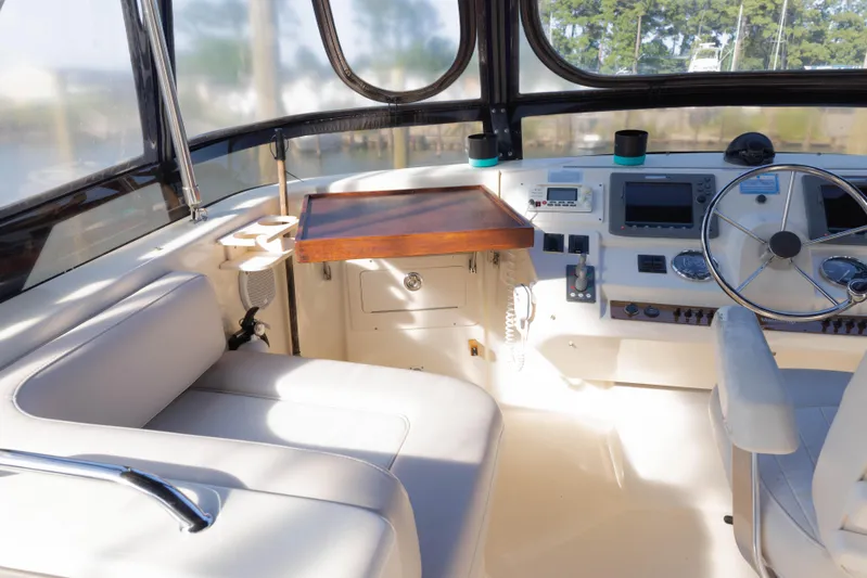 Figur'in It Out Yacht Photos Pics 2006 Mainship 400 Trawler helm with steering wheel, navigation controls, and seating.