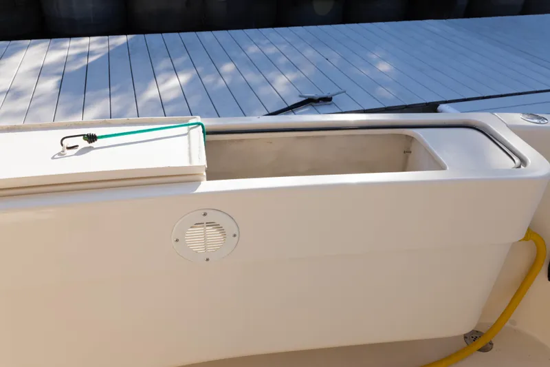 Figur'in It Out Yacht Photos Pics 2006 Mainship 400 Trawler deck detail with storage compartment and dock background.