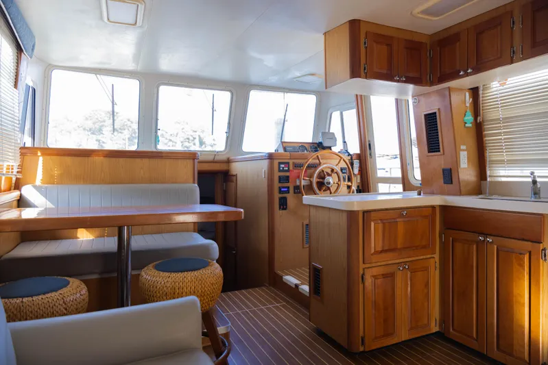 Figur'in It Out Yacht Photos Pics 2006 Mainship 400 Trawler interior with wooden cabinetry, dining area, and helm station.