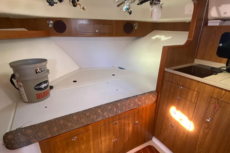  Yacht Photos Pics 2009 Pursuit OS 375 Offshore cabin interior with wooden cabinetry and fishing gear.