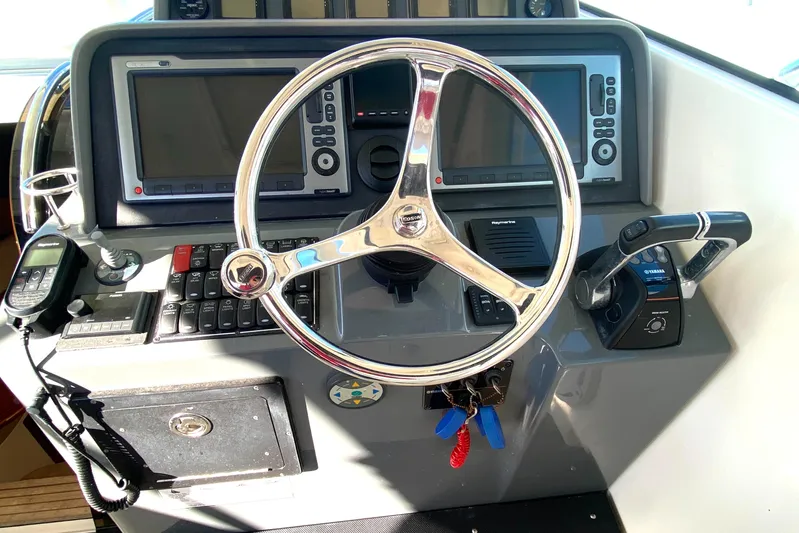  Yacht Photos Pics Helm of 2009 Pursuit OS 375 Offshore boat with steering wheel and navigation controls.