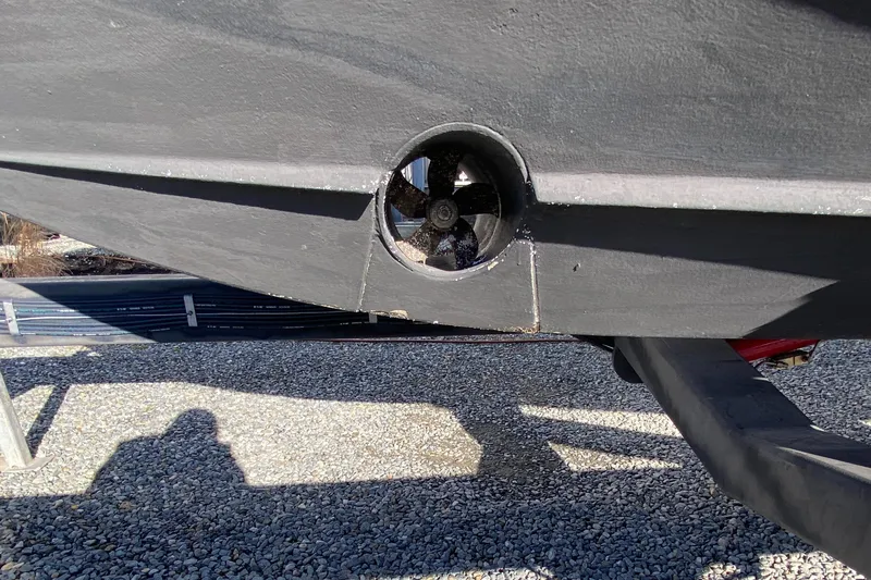  Yacht Photos Pics 2009 Pursuit OS 375 Offshore boat hull with visible thruster on gravel surface.