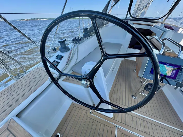Ahyoka Yacht Photos Pics Steering wheel of 2017 Hanse 345 sailboat with navigation equipment, on calm waters.