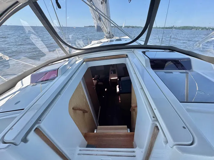 Ahyoka Yacht Photos Pics 2017 Hanse 345 sailboat cockpit with open cabin door, sailing on a calm sea.