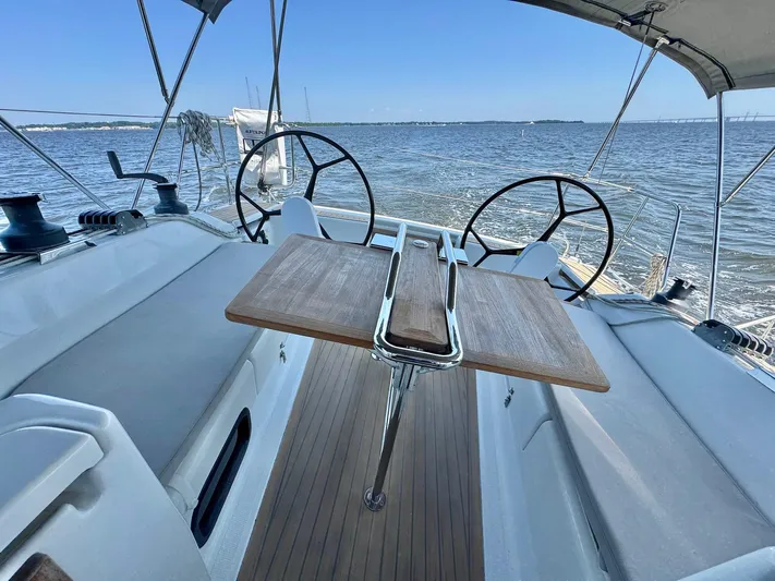 Ahyoka Yacht Photos Pics 2017 Hanse 345 sailboat cockpit with dual steering wheels and wooden table on open water.
