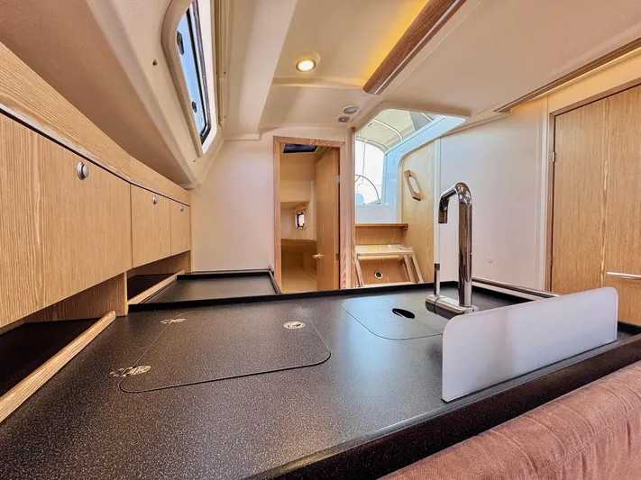 Ahyoka Yacht Photos Pics Interior of 2017 Hanse 345 yacht, featuring modern kitchen with sleek countertops and wood cabinetry.