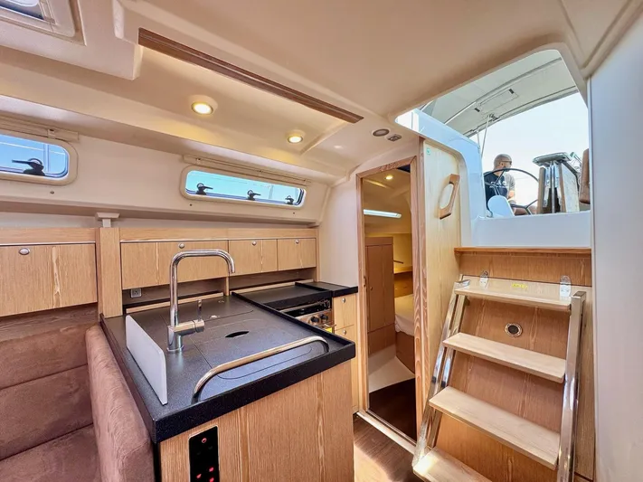 Ahyoka Yacht Photos Pics Interior of 2017 Hanse 345 yacht with modern kitchen and wooden stairs.