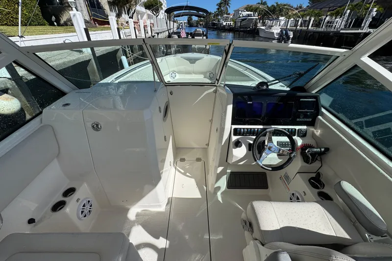  Yacht Photos Pics 2025 Sailfish 276 DC boat interior with modern dashboard and seating, docked by the water.