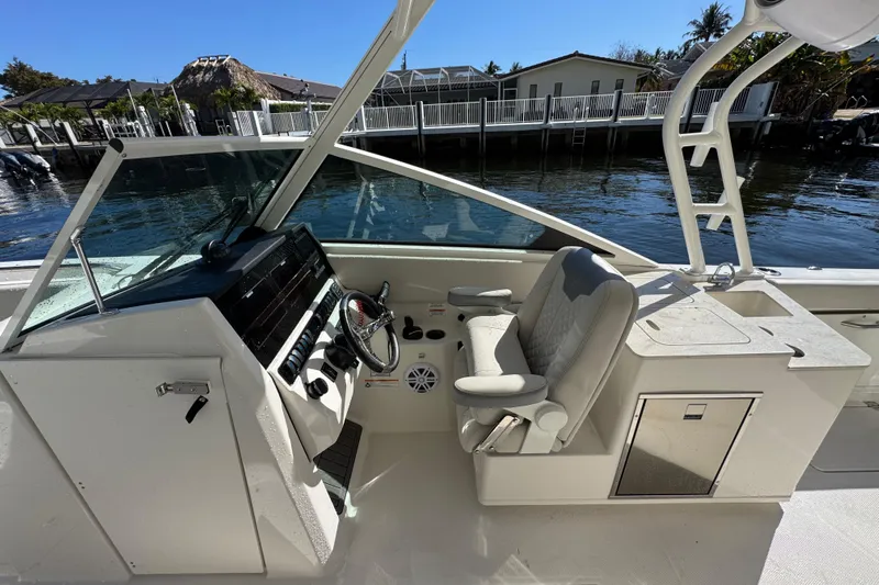  Yacht Photos Pics 2025 Sailfish 276 DC boat cockpit with steering wheel and seating, dockside view.