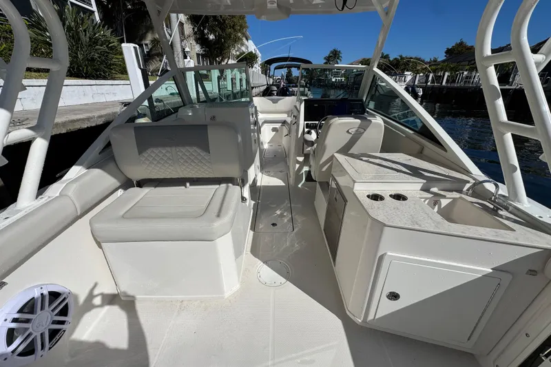  Yacht Photos Pics 2025 Sailfish 276 DC boat interior with seating, helm, and kitchenette on a sunny day.