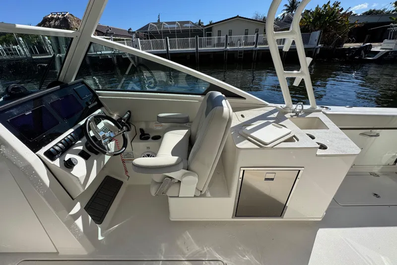  Yacht Photos Pics 2025 Sailfish 276 DC boat interior with helm, seating, and sink by the water.