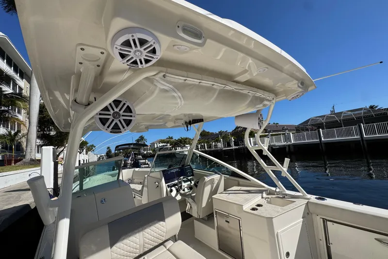  Yacht Photos Pics 2025 Sailfish 276 DC boat interior with speakers and seating, docked by waterfront homes.