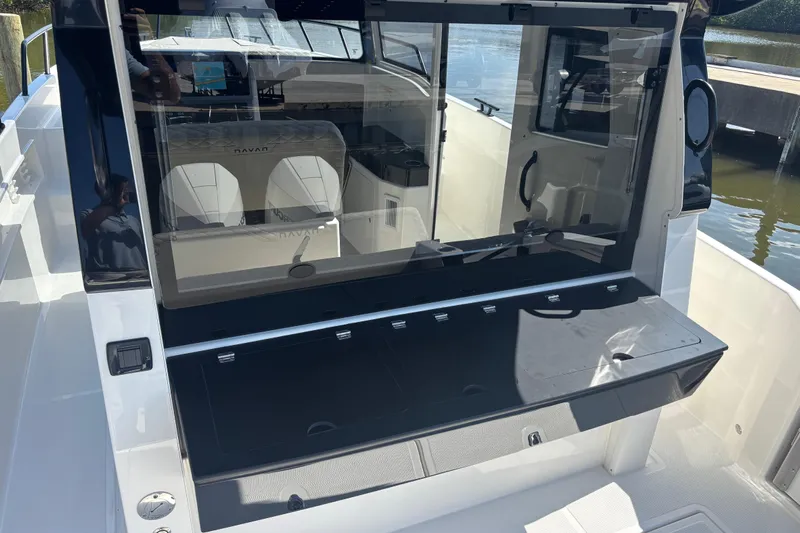  Yacht Photos Pics 2026 Navan C30 boat interior with seating and control panel, docked by the water.