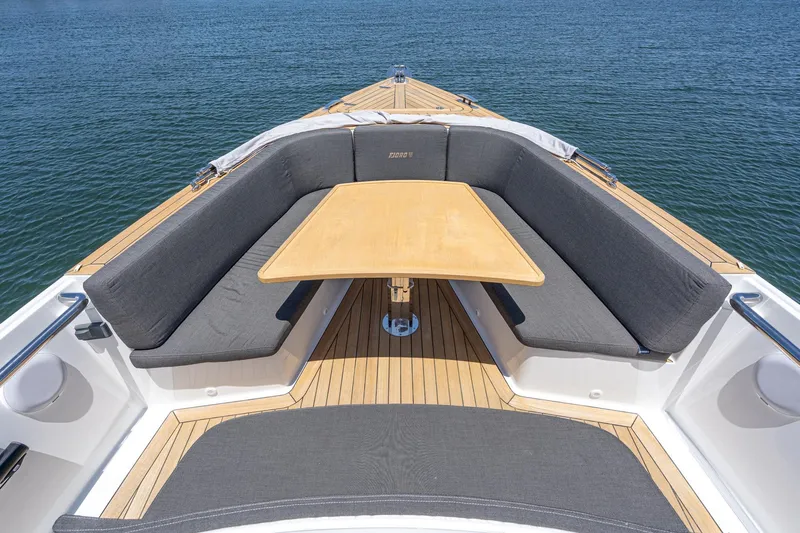 Intermezzo Yacht Photos Pics 2018 Fjord 36 Xpress boat with teak deck, cushioned seating, and central table on calm water.