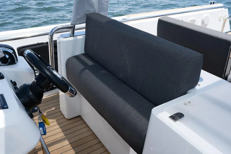 Intermezzo Yacht Photos Pics 2018 Fjord 36 Xpress boat interior with steering wheel and cushioned seating.