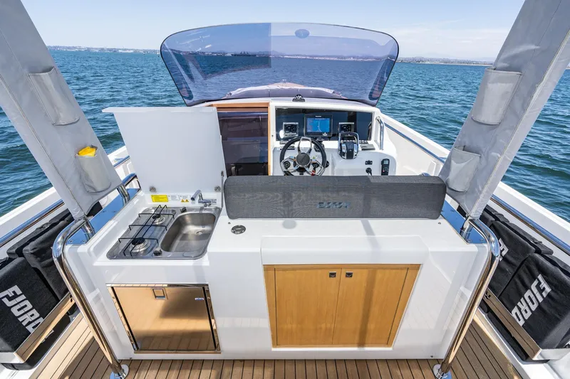 Intermezzo Yacht Photos Pics 2018 Fjord 36 Xpress yacht cockpit with kitchen, steering wheel, and navigation equipment.