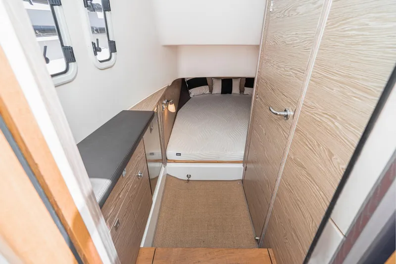 Intermezzo Yacht Photos Pics 2018 Fjord 36 Xpress cabin interior with bed, wooden cabinetry, and windows.