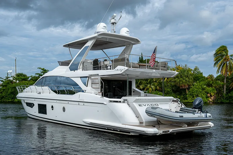 Evado Yacht Photos Pics 2020 Azimut 66 yacht on a serene waterway with lush greenery.