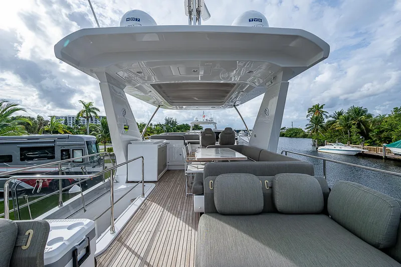 Evado Yacht Photos Pics Luxurious 2020 Azimut 66 yacht deck with seating and scenic waterfront view.