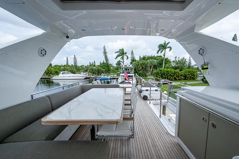 Evado Yacht Photos Pics Luxurious 2020 Azimut 66 yacht interior with elegant dining area and scenic marina view.