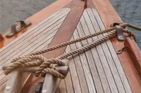 Bow of 1905 PLYMS Prototype Sloop with wooden deck and rope details.