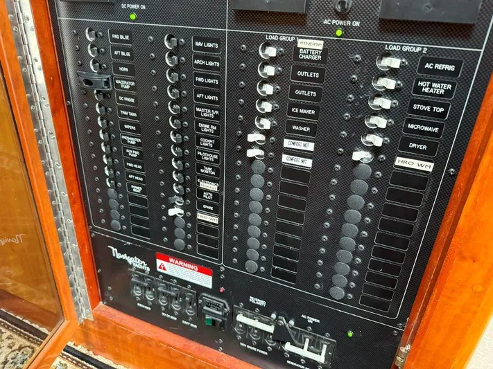  Yacht Photos Pics Electrical control panel of a 2003 Navigator 4800 boat with labeled switches and indicators.