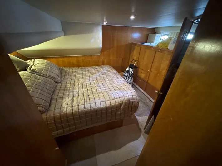  Yacht Photos Pics Cozy bedroom in 2003 Navigator 4800 yacht with wood paneling and plaid bedding.