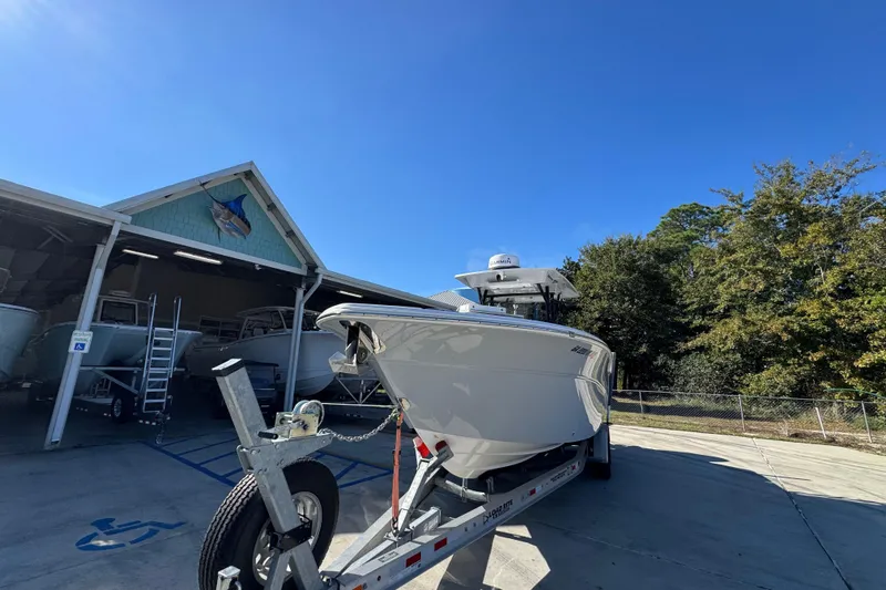  Yacht Photos Pics 2022 Sea Fox 288 Commander boat on trailer, parked outside a boathouse under clear blue sky.